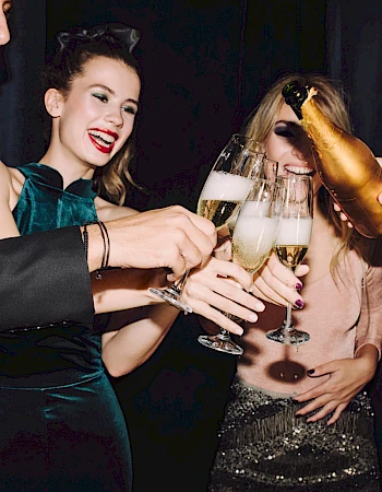 Friends celebrate with champagne toasts at a party.