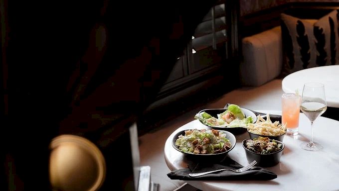 a table with food and drinks in a dimly lit restaurant