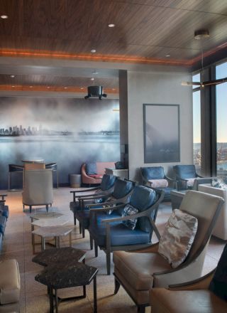 A modern lounge with comfortable seating, large windows with an ocean view, and sleek decor, creating a stylish and relaxing atmosphere.